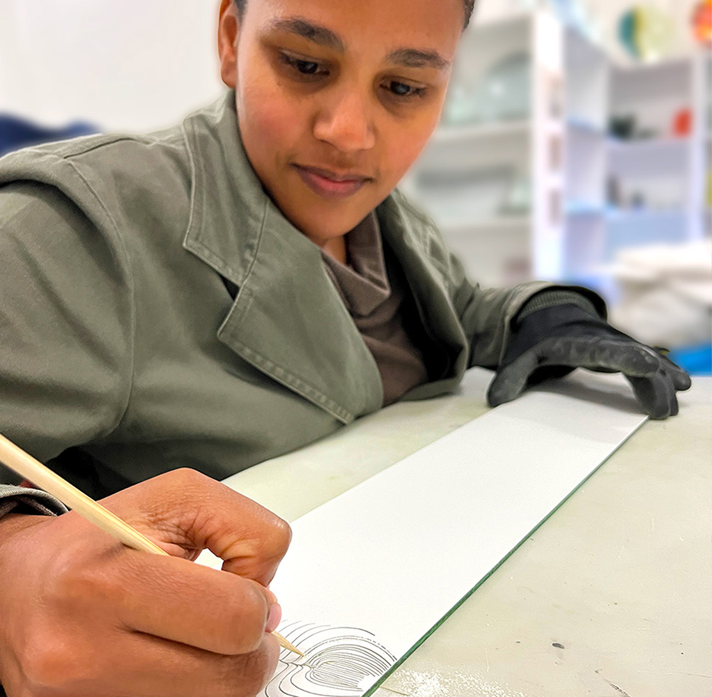 A Fanglasstic artist doing a design on glass.